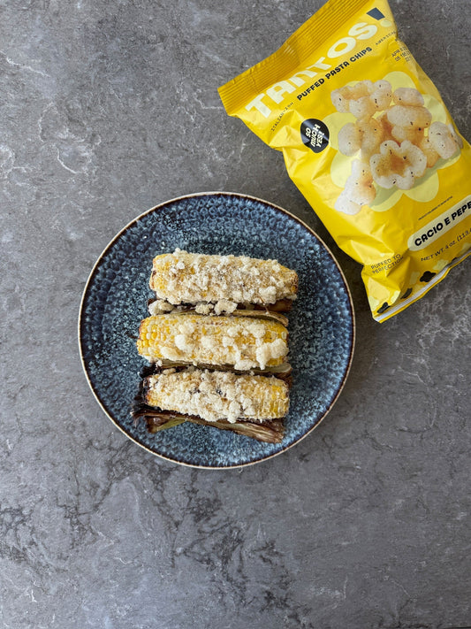 Grilled corn coated in crushed Cacio e Pepe Tantos